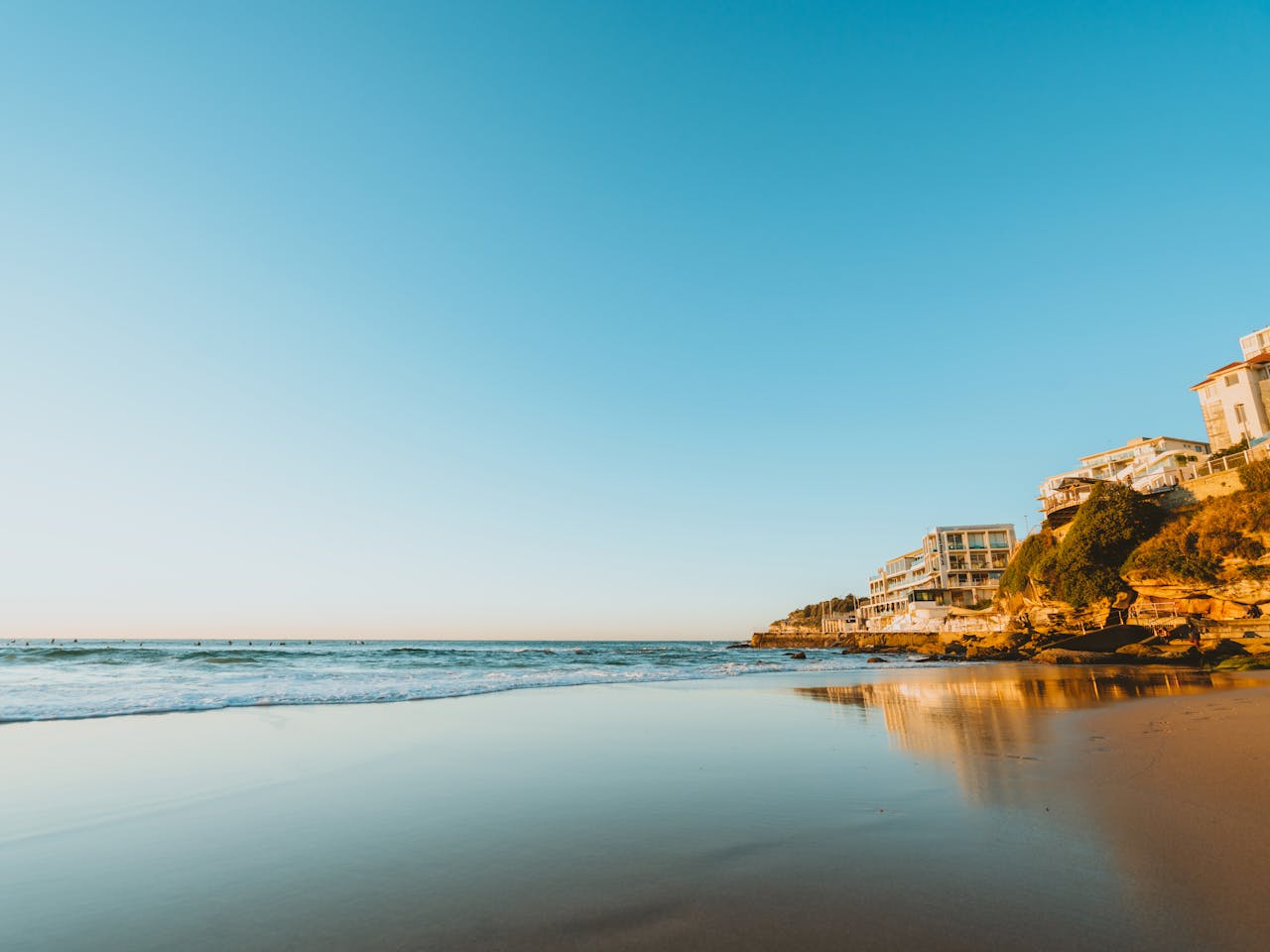 Stunning sunset at Bondi Beach, showcasing ocean waves and coastal homes.